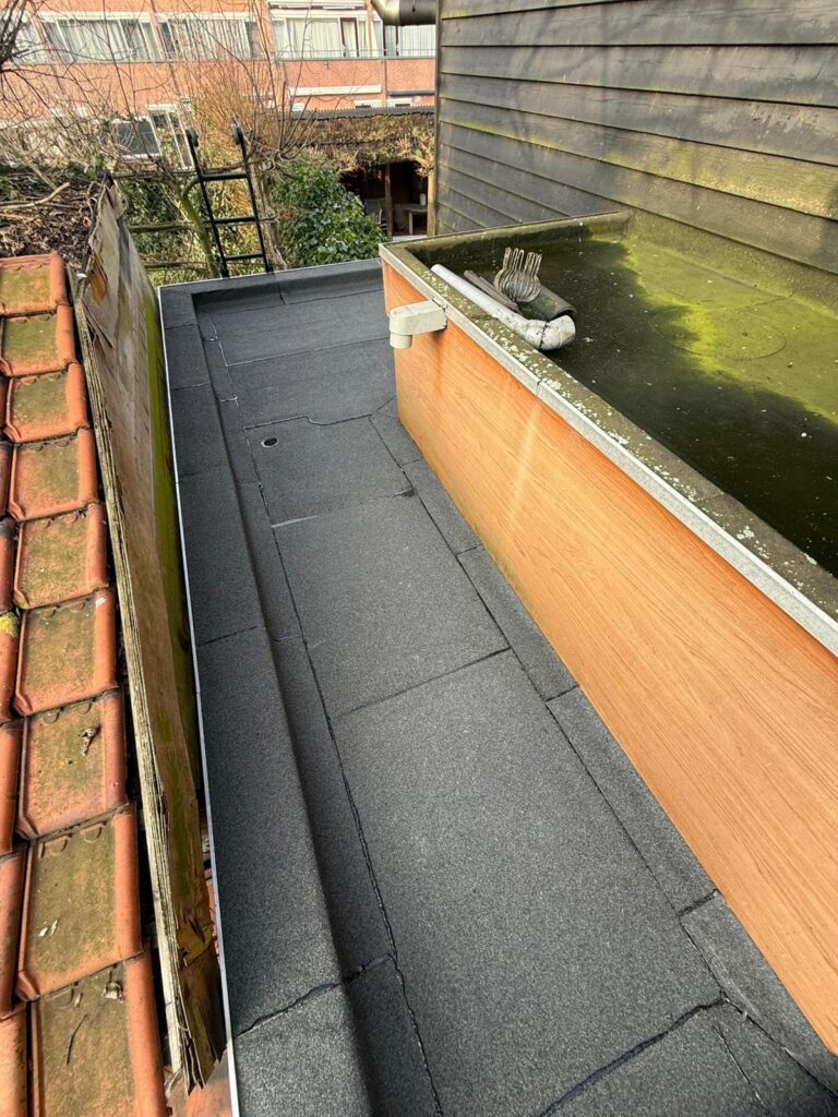 Nieuw overlaagd bitumen dak met aluminium daktrim op een aanbouw in Maassluis