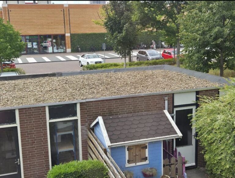 Renovated flat roof with new bitumen roofing and gravel layer in Maassluis