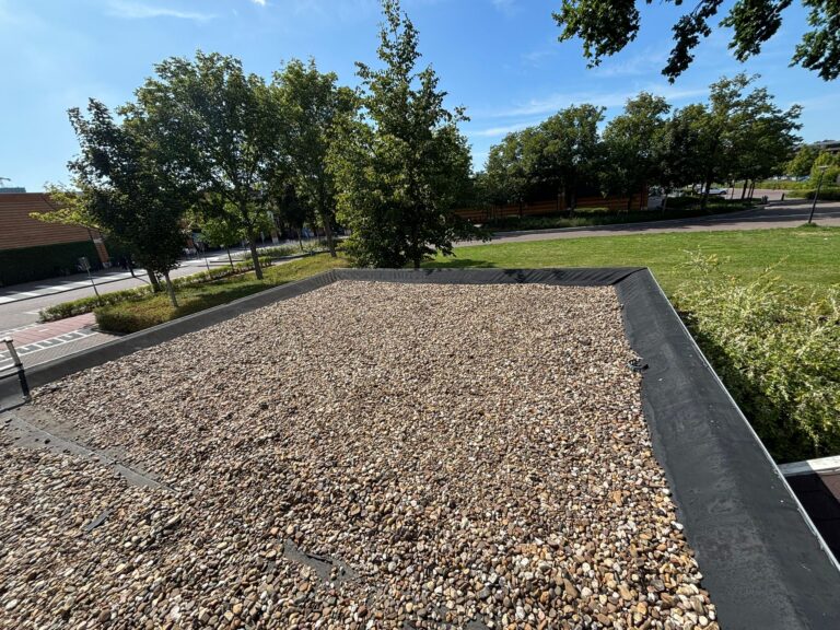 Renovated flat roof with new bitumen roofing and gravel layer in Maassluis
