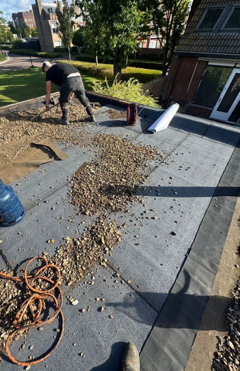 Renovated flat roof with new bitumen roofing and gravel layer in Maassluis